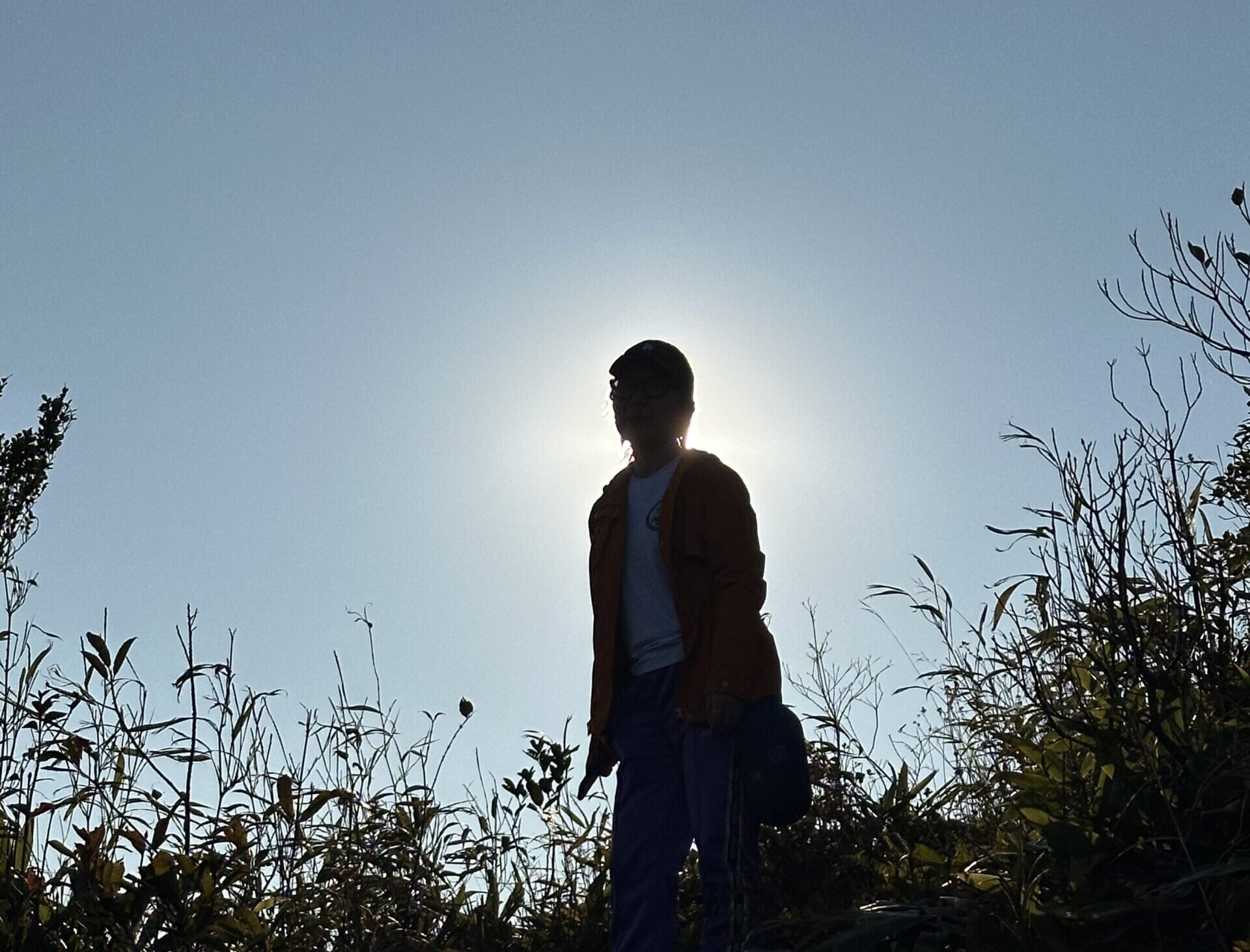 Falls standing against the sun on the top of the mountain.