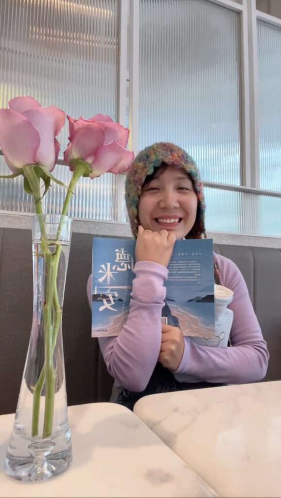 Falls smiling holding a blue book
