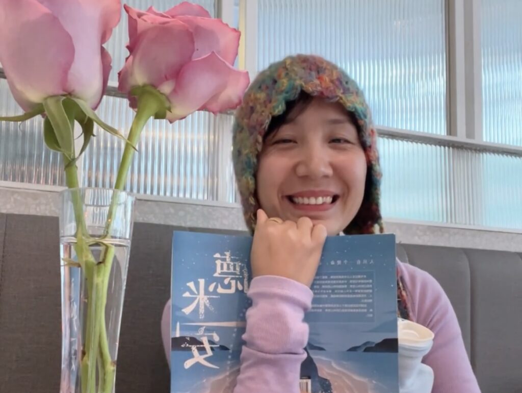 Falls with a book smiling to the camera