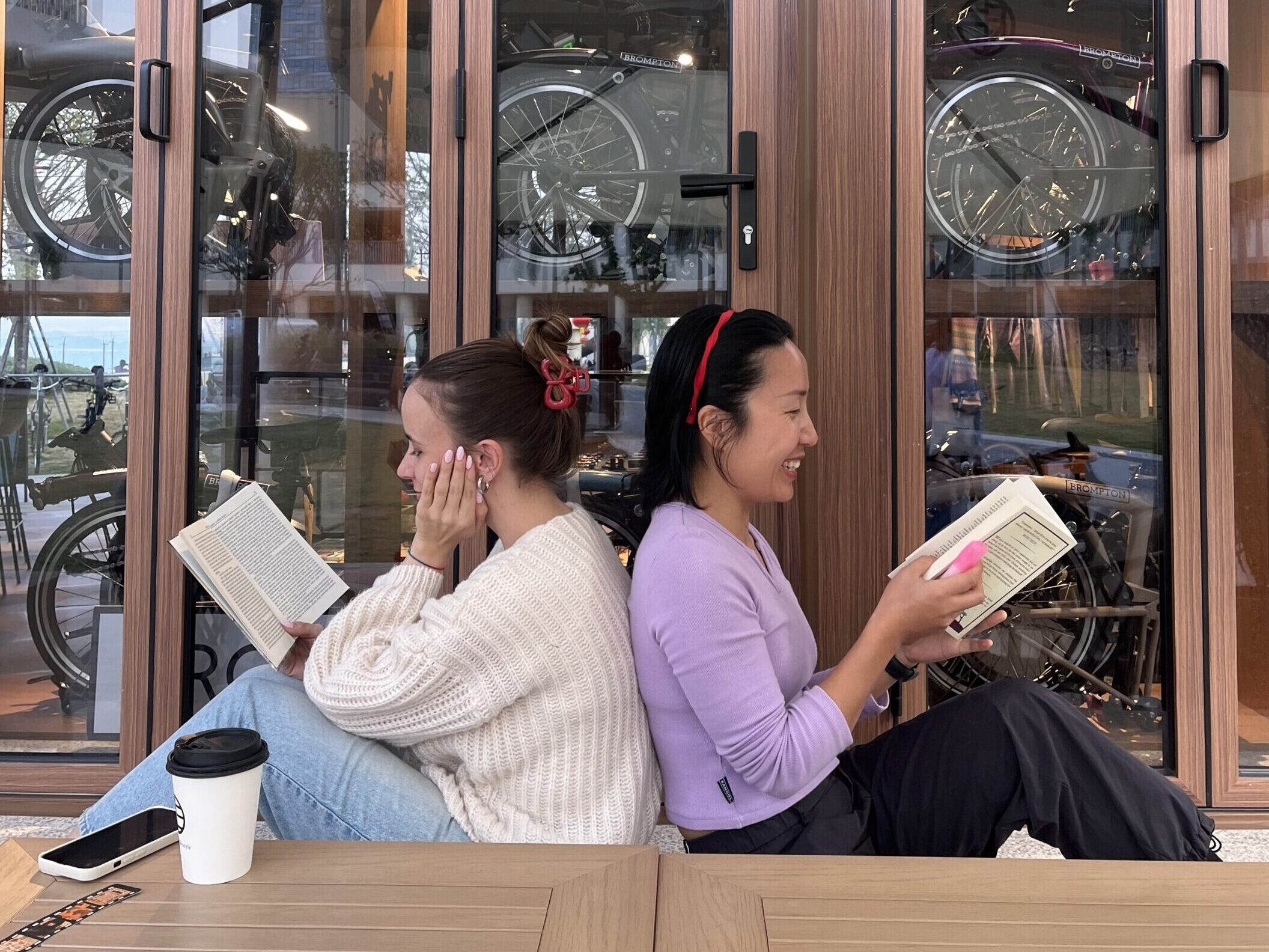 Falls and Nina sitting back to back reading