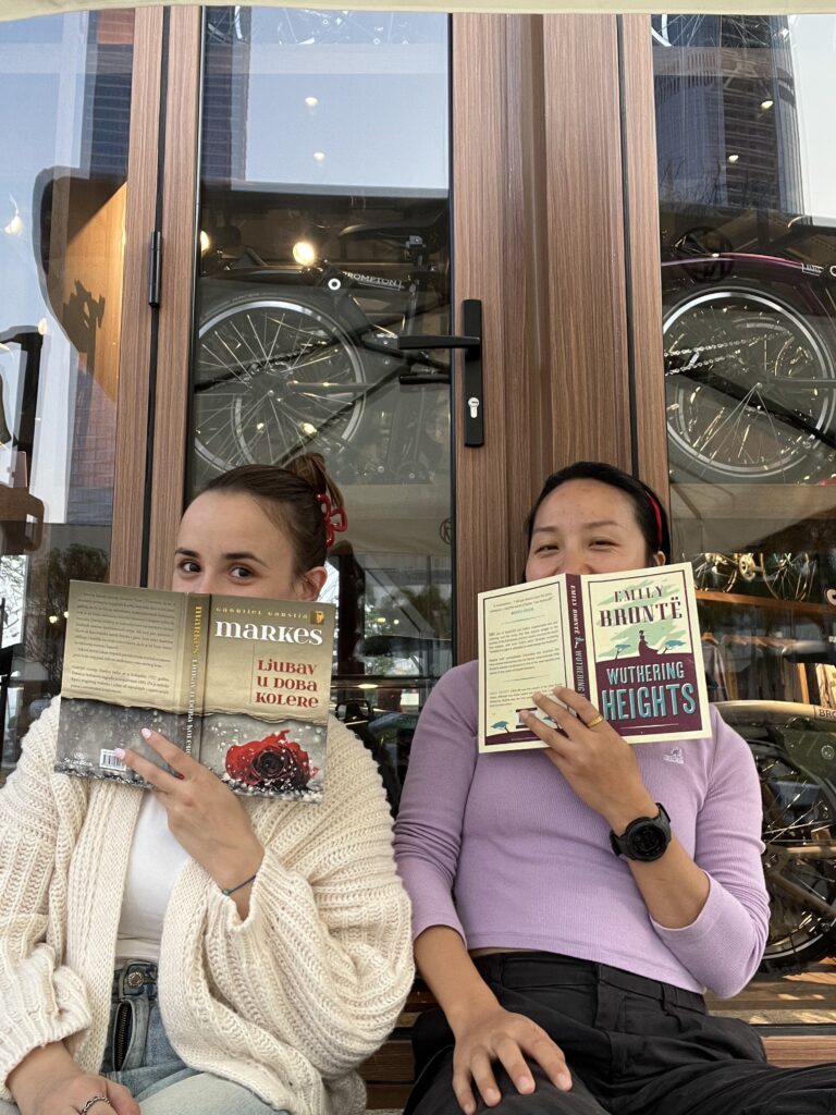 Falls and Nina each holding a book. 