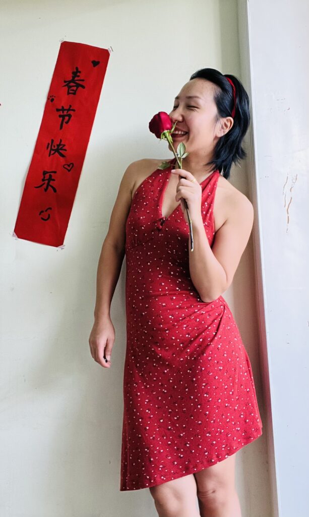 Falls wearing a red dress with a rose smiling
