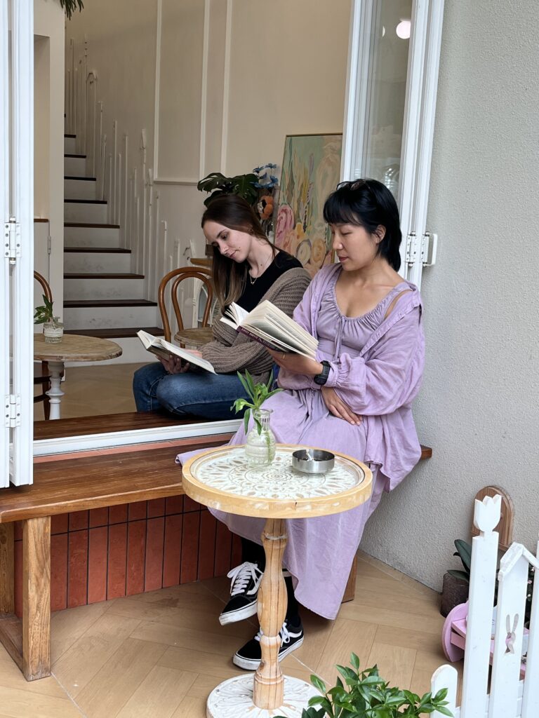Two girls reading by the window.