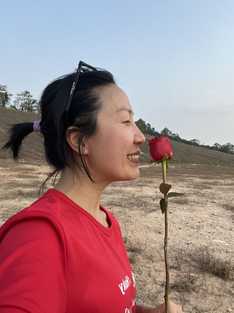 A girl sniffs a rose