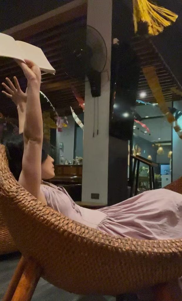 Relaxing on a bench with a book in hand, stretching and enjoying a slow holiday.