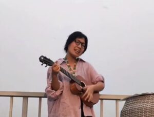 Playing the ukulele on a rooftop during a peaceful evening of travel.