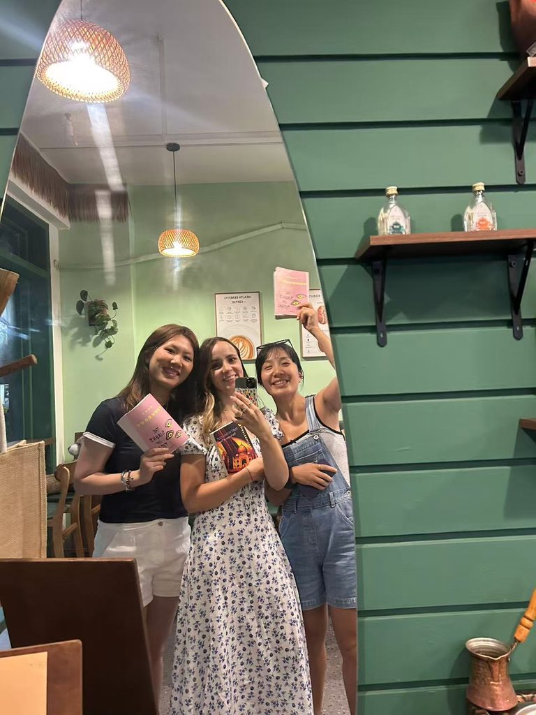 A group selfie of the Fallina Reading Club members taking a mirror photo together during a meet-up.