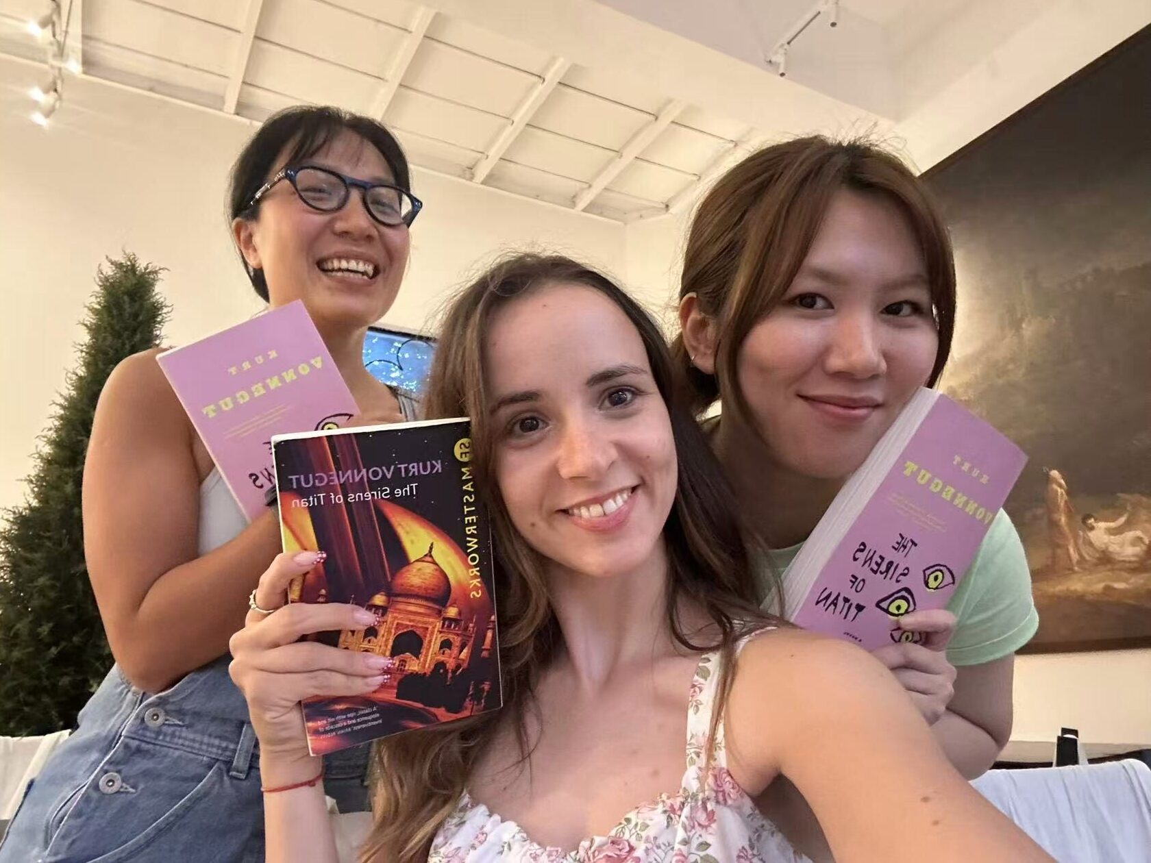 Group photo showing three members of Fallina reading club holding books
