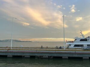 A peaceful seaside evening after the rain, with soft sunset colors appearing in the sky