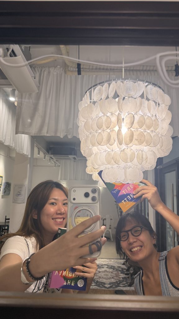 Two friends taking a mirror selfie with The Vanishing Half