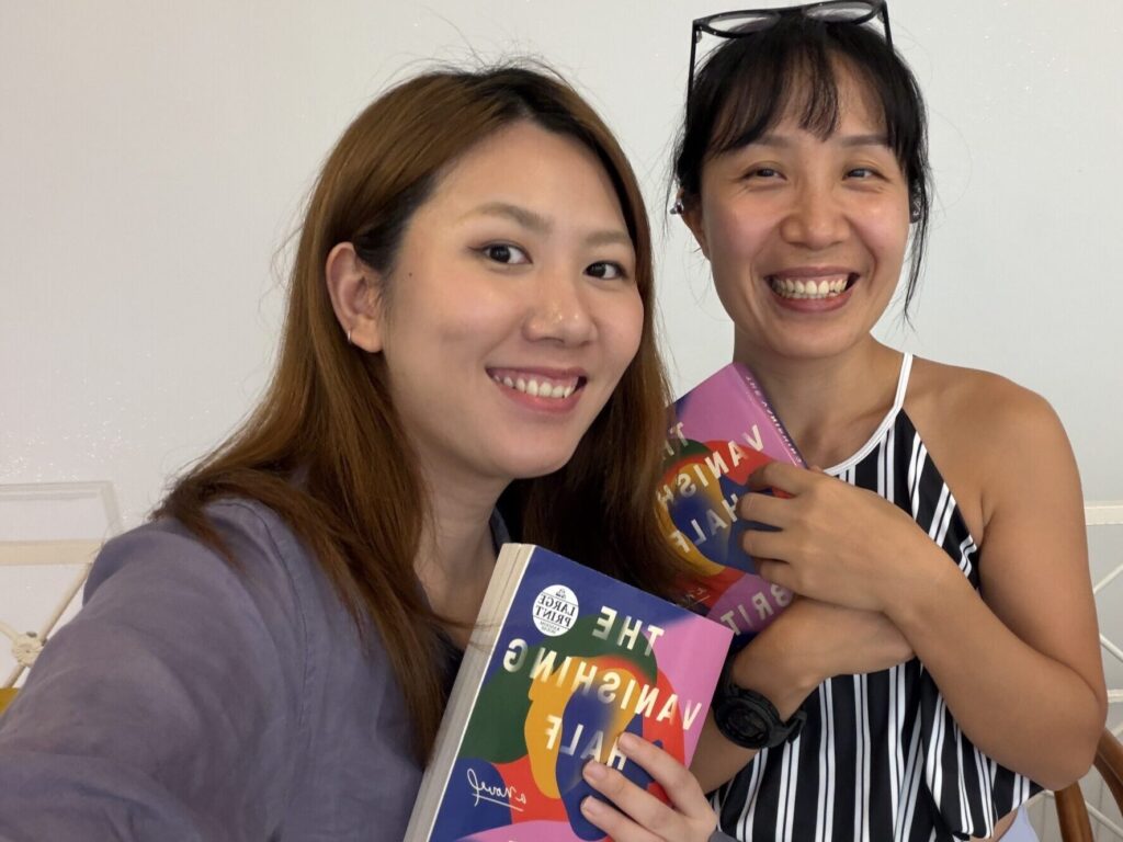Two members of Fallina Book Club holding The Vanishing Half during a reading session