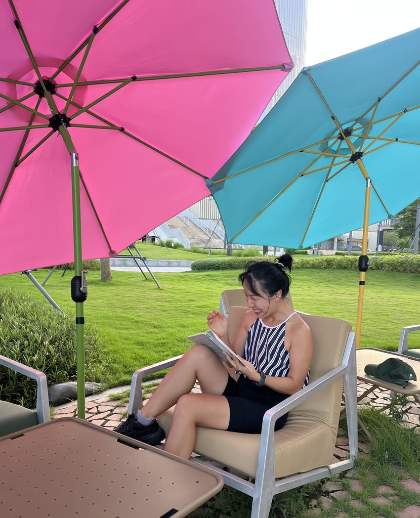 Falls smiling with a book on a outdoor chair during a relaxing reading moment