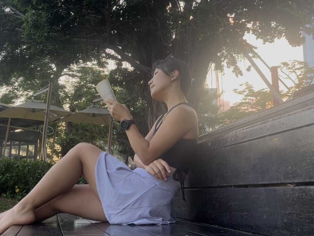 Falls reading a book under a tree at sunset, embracing a peaceful and intentional moment