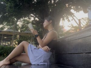 Falls reading a book under a tree at sunset, embracing a peaceful and intentional moment