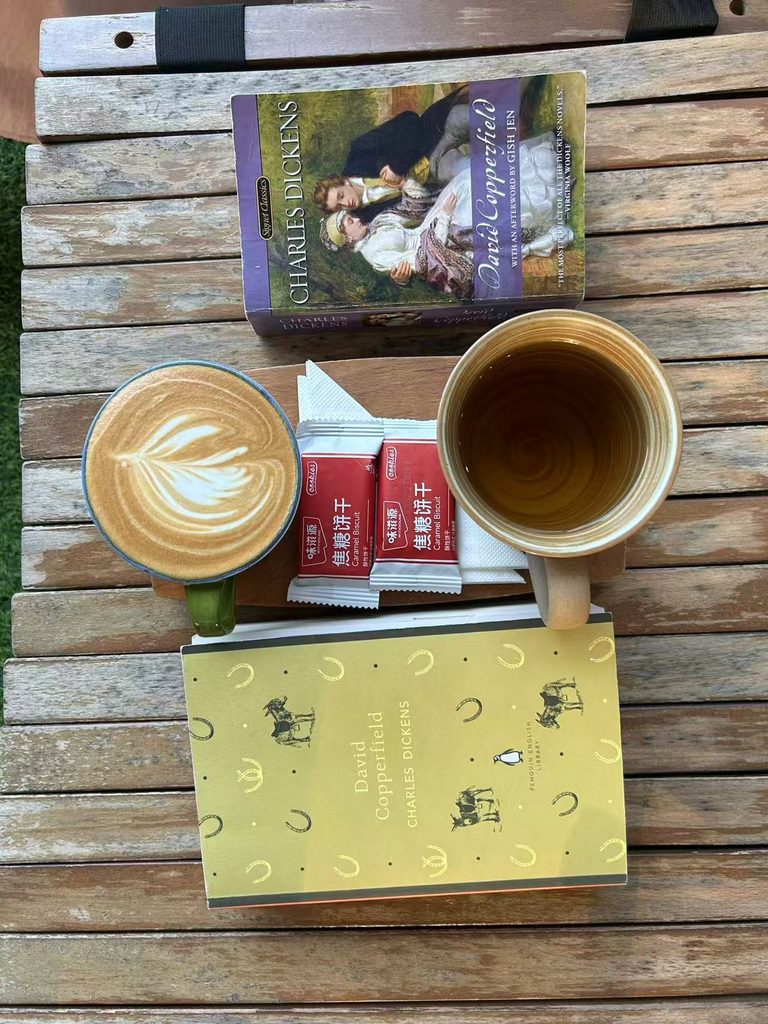 Two copies of David Copperfield with tea and coffee on a table