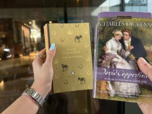 Falls and Nina holding their copies of Charles Dickens books during a Fallina reading session
