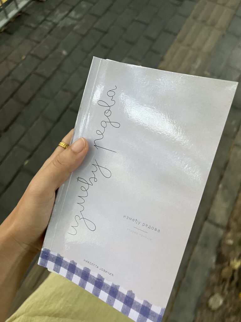 Falls holding Nina's poetry book during a Fallina reading session